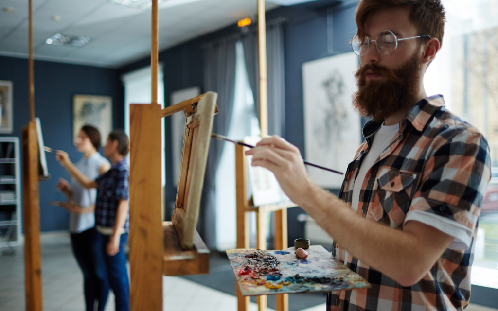 Man at easel in art class