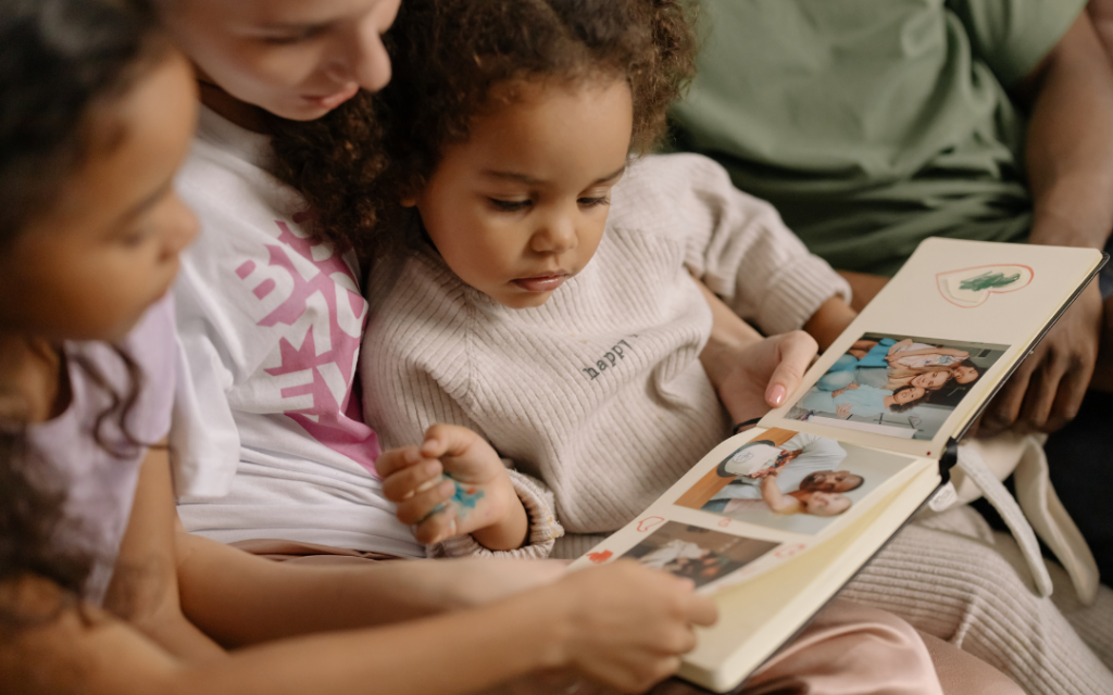 Mother and daughters looking at photo album