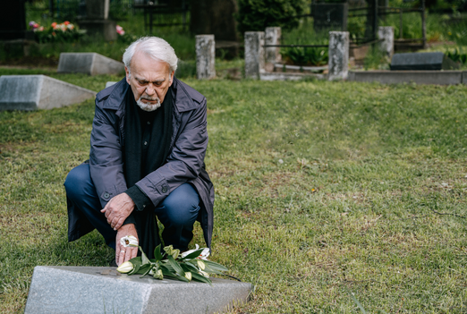 Man mourning at gravesite